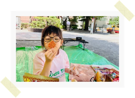 4歳の女の子がピクニックでお菓子を食べている様子