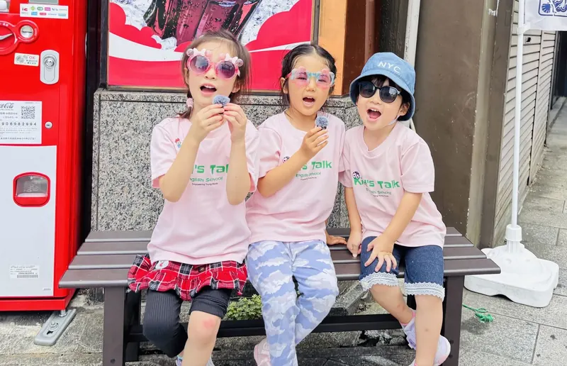 ベンチでお菓子を食べる女の子たち
