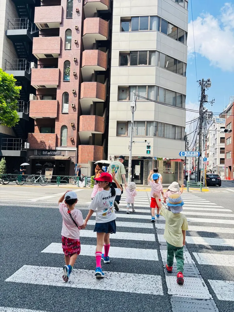 KID'S TALK 神田司町が入っている鈴木ビルと、横断歩道を渡る子どもたち