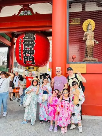 浅草寺の雷門の前で、浴衣姿の子どもたちと講師が記念撮影