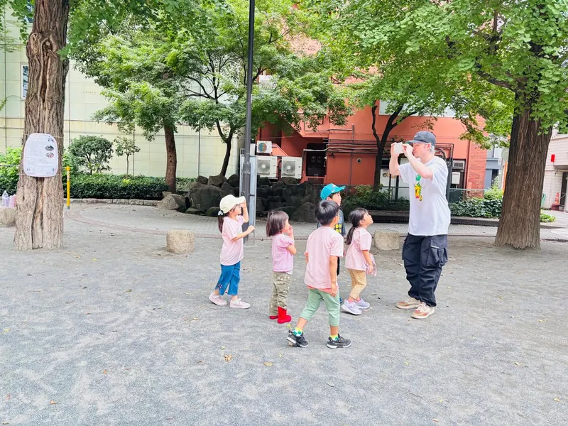 公園で子どもたちが講師と外遊びをしている様子