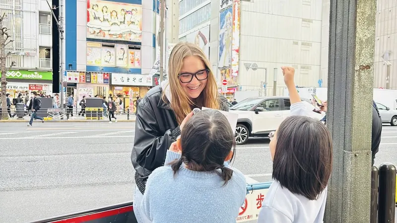 講師が小学生の女の子2人と英語で会話している様子